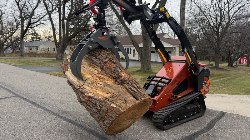 Professional tree removal service in Macomb County using a Ditch Witch log loader to safely clear heavy timber.